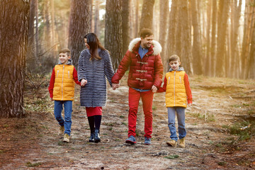 happy family wit twins children in spring forest walking and smiling 