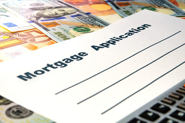 Mortgage application form with a pen and money.