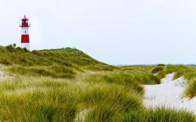 Lighthouse List-Ost inside a Dune Landscape with grass and sand. Detail view on a clear day. Located in List auf Sylt, Schleswig-Holstein, Germany.
