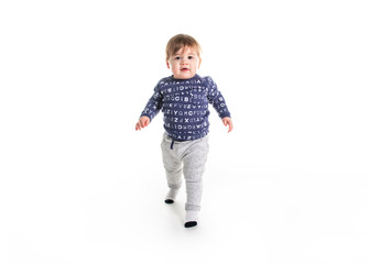 A One year old boy walk on studio white background