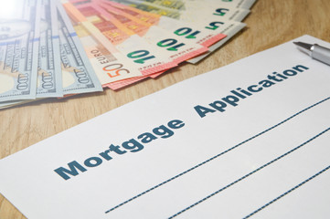 Mortgage application form with a pen and money.