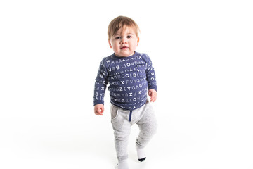A One year old boy walk on studio white background