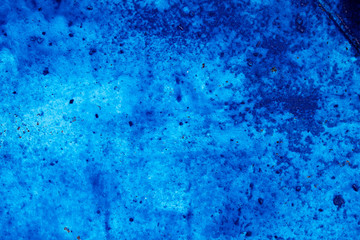 Textures on the blue wall, for background. Grungy blue concrete wall background.