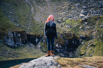 Happy Woman standing on top of a mountain, hiking, travel active lifestyle. Transfagarasan Romania