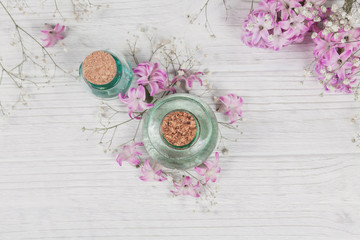 Abstract composition of fresh purple hyacinths flowers and bottles of organic cosmetic with essential oil