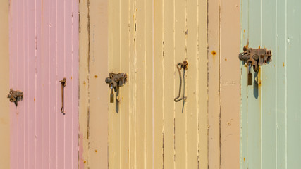 Coloured doors and locks of beach huts on the beach of Budleigh Salterton, Jurassic Coast, Devon, UK