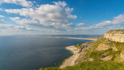 Fototapeta na wymiar South West Coast Path on the Isle of Portland, looking towards Fortuneswell and Chesil Beach with Weymouth in the background, Jurassic Coast, Dorset, UK
