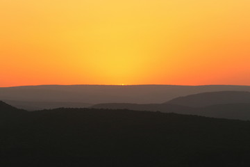 Abstract sunset scene with shades of oranges and greys.