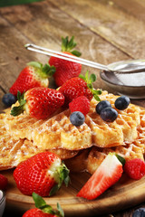 Waffle. Traditional belgian waffles with fresh fruit and powder sugar on wood