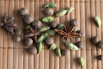 Black pepper, cardamon with stars anice on wooden back ground.