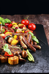 Assorted delicious grilled meat and skewer with vegetable on rustic table