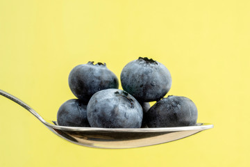 Healthy blueberries close up macro on yellow background