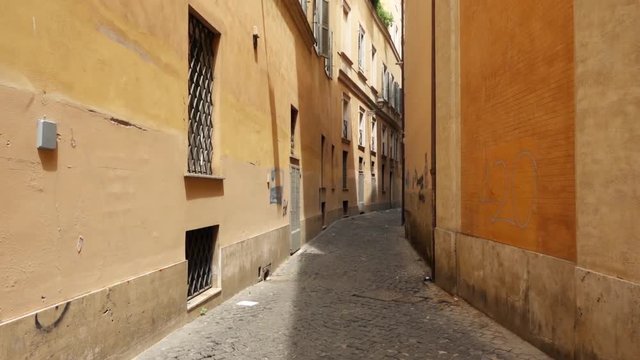 First person view of someone walking along deserted alley in Rome, Italy. POV of tourist going through narrow street