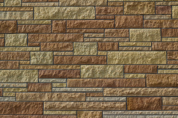 Attractive kasota limestone brick wall background with bricks in varying shades of brown