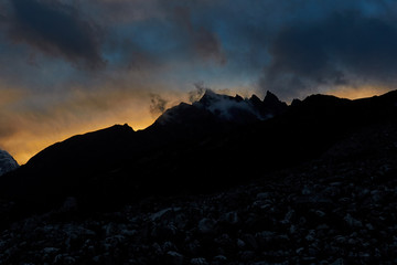 huge Himalayan mountain  with a glaciers in Nepal covered by clouds before the sunrise