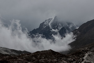 huge Himalayan mountain  with a glaciers in Nepal covered by clouds