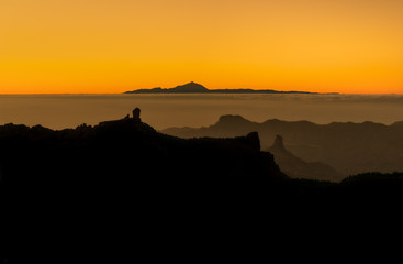 beautiful panoramic view of volcano Teide of Tenerife and Pico Roque Nublo of Gran Canaria during golden sunset