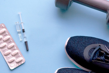 The concept of doping in sport. Sports shoes, pills, syringe with medicine, fillett.