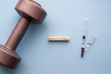 The concept of doping in sport. Inscription Doping on a blue background. Syringe with medicine,...