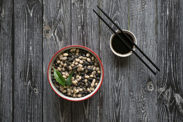 Stewed beans with soy sauce on a wooden table. 