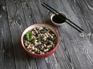 Stewed beans with soy sauce on a wooden table. 