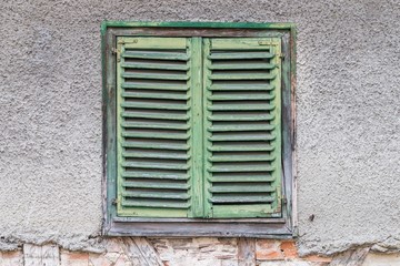 Fototapeta na wymiar Altes Fenster mit geschlossenen Fensterläden aus Holz, Deutschland