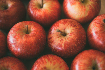 Red fresh apples as background. Close up view of heap of delicious apples as texture and background. 