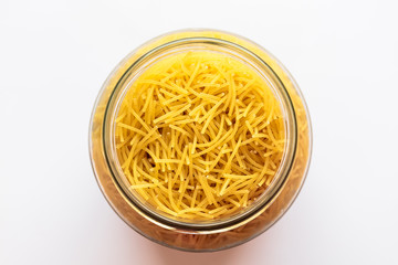 Uncooked vermicelli pasta in glass bowl isolated on white background