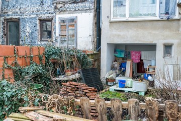 Heruntergekommener sozialer Wohnungsbau in einem sozialen Brennpunkt mit Müll im Garten, Deutschland