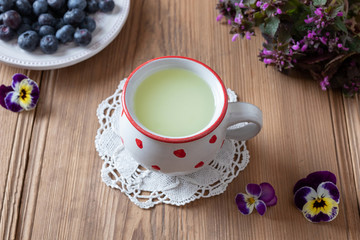 Fresh whey in a mug with blueberries and flowers