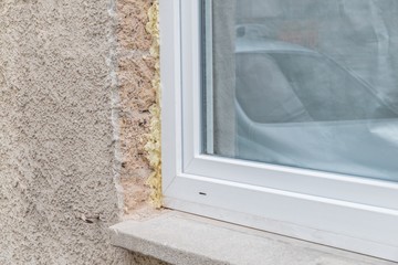 Nahaufnahme eines Fensters im Rohbau mit Bauschaum und Fensterbrett, Deutschland