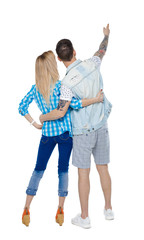 Back  view of a heterosexual couple who hugs and points out.