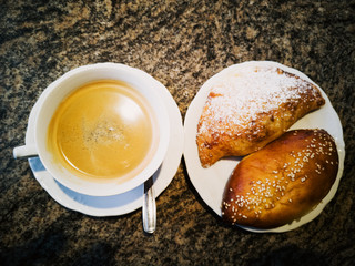 cup of coffee and croissant on table