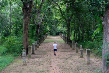 Tourist walking down a path at the Angkor world heritage site in Cambodia