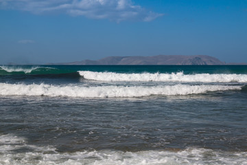 Sea with waves and a mountain on a horizon