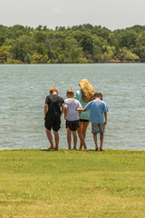 Obraz premium curious children standing next to the water at a lake