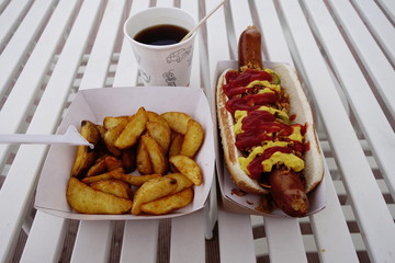 Hot-dog with mustard, ketchup, pickles, onions, fries and coffee