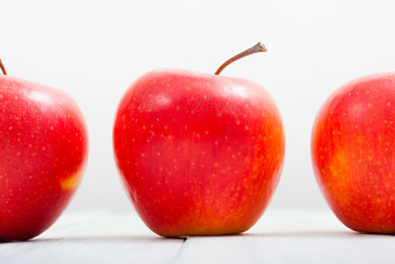 apple fruits in a row, white wooden table background