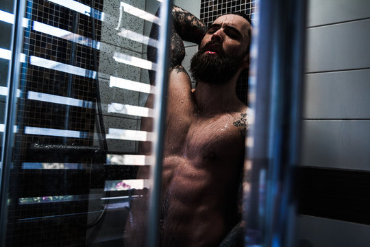 A bearded guy with a tattoo in the shower.Sexy guy in the shower.