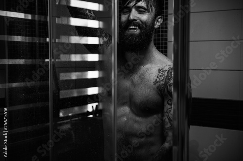 Muscly guy in tats showering
