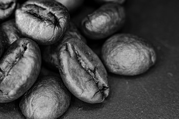Obraz premium Brown roasted coffee beans on black background, close up, macro