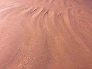 patterns from the waves and wind on the sand, sand of an unusual color