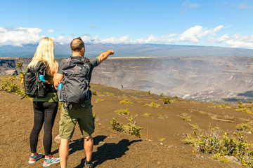 The Hiking couple seeing volcano national park from crater on the caldera Halemaumau around Hawaii...
