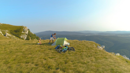 DRONE: Carefree tourists set up their tent after mountain biking in the Alps.