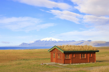 Fototapeta na wymiar Cabin at the sea with snow mountain in background (Snæfellsnes Iceland)