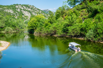 MONTENEGRO, CRNOJEVIC RIVER - JUNE 08/2017: motorboat carries tourists to the scenic spots of the beautiful river.