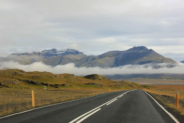 Road with clouds and mountains in background (Iceland)