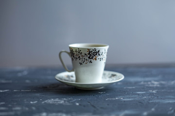 White cup with black coffee on a dark background