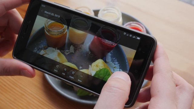 Food photo man takes pictures via smart phone of dish in cafe bistro during breakfast for social media