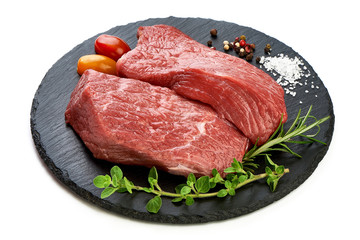 Fresh raw beef steaks on slate shale plate, sliced meat, close-up, isolated on white background